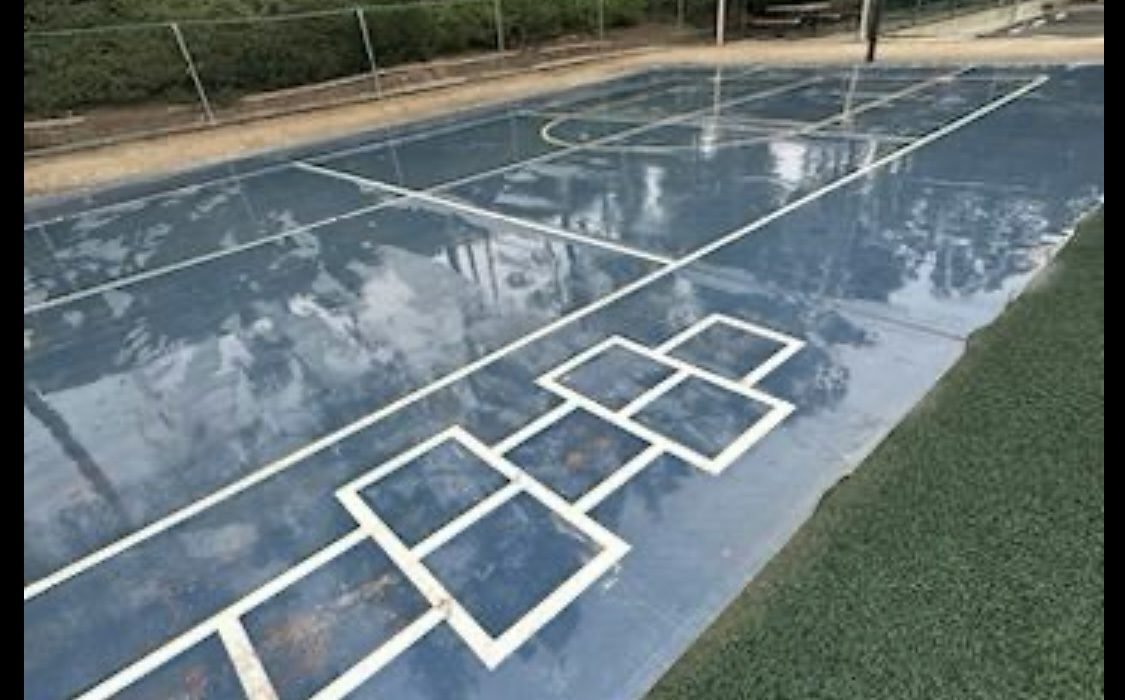 Wet outdoor basketball/multi-use court after cleaning